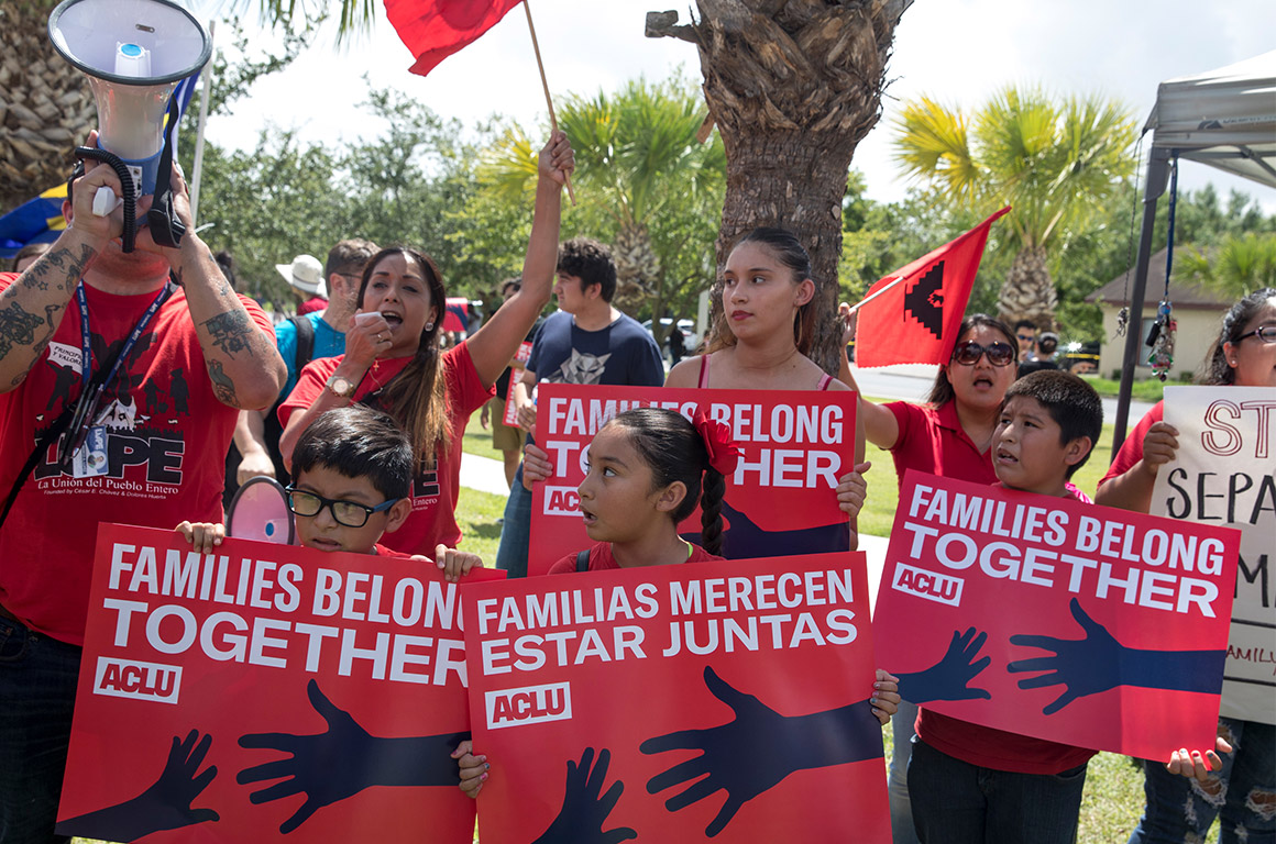 Demonstrators carrying signs with the text &quot;Families Belong Together&quot;