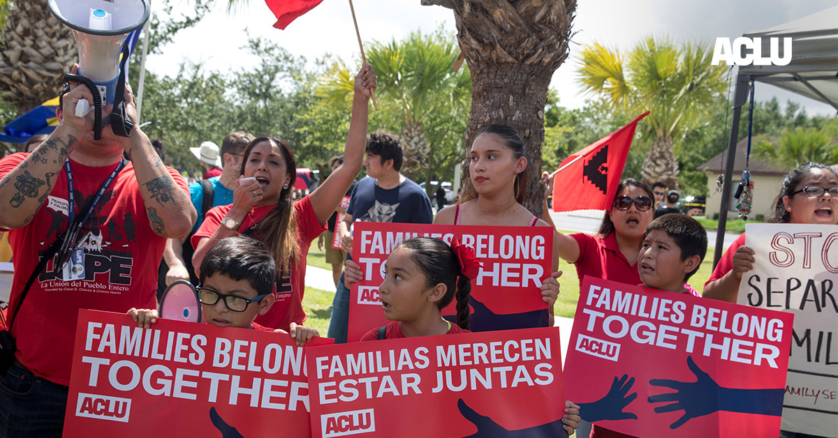 Demonstrators carrying signs with the text &quot;Families Belong Together&quot;